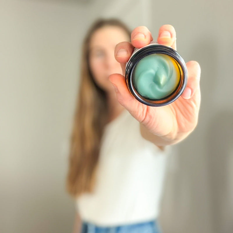 Woman holding open jar of Edenwild Blue Tansy Tallow Balm — natural blue tansy skincare for reactive and inflamed skin