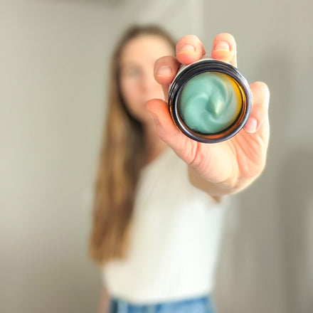 Woman holding open jar of Edenwild Blue Tansy Tallow Balm — natural blue tansy skincare for reactive and inflamed skin