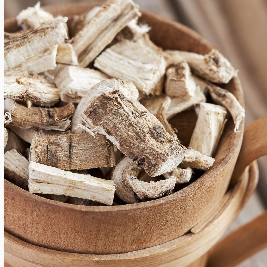 Got it! Here's the updated alt text:  **`Dried marshmallow root chunks in a wooden bowl, a soothing botanical ingredient used in natural skincare for sensitive and dry skin