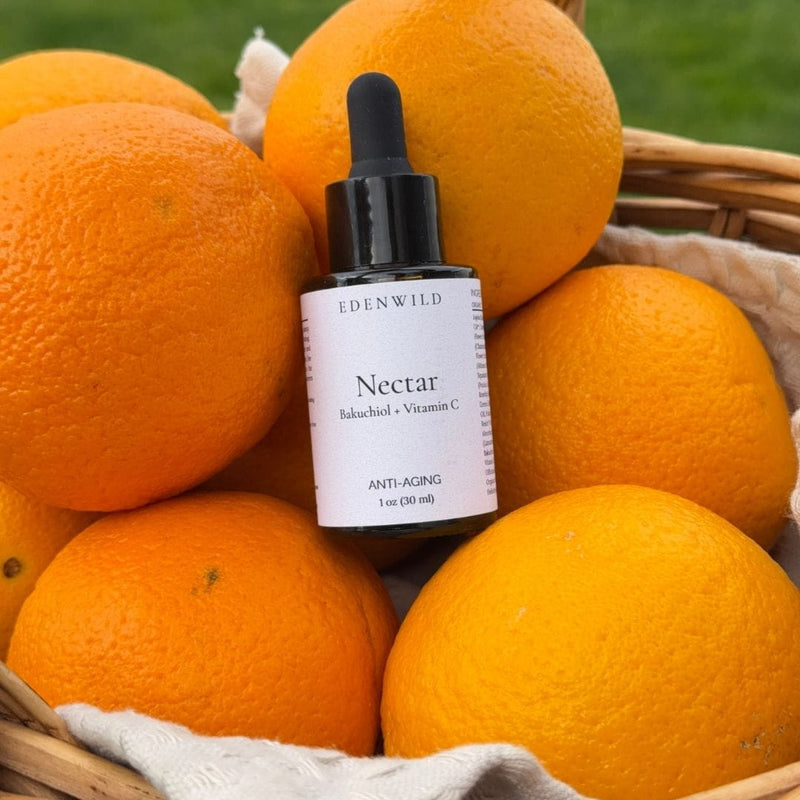 Edenwild Nectar serum — bakuchiol and vitamin C anti-aging facial oil in a dropper bottle nestled in a basket of fresh oranges - retinol-free