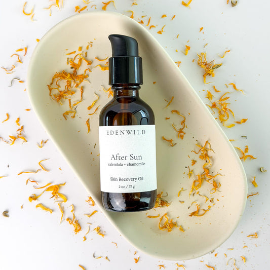 Edenwild After Sun Skin Recovery Oil surrounded by dried calendula and chamomile flowers — natural after sun recovery oil for sun-damaged and irritated skin