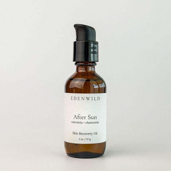 Edenwild After Sun Skin Recovery Oil with calendula and chamomile in amber pump bottle on grey background — botanical after sun oil for skin repair and redness relief