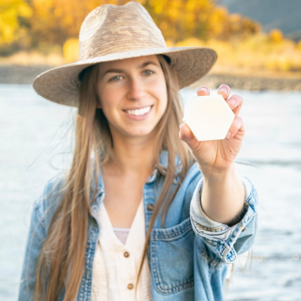Woman holding Edenwild Aire solid conditioner bar outdoors — plant-based conditioner bar for smooth, frizz-free, and moisturized hair