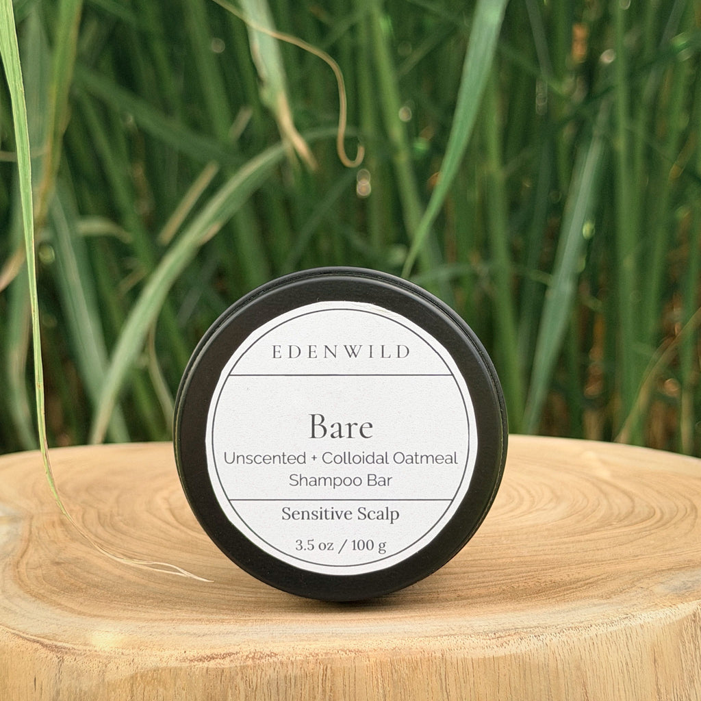 Edenwild Bare Shampoo Bar on wood stump pedestal with natural grass background — unscented colloidal oatmeal shampoo bar for sensitive scalp, fragrance-free and sulfate-free