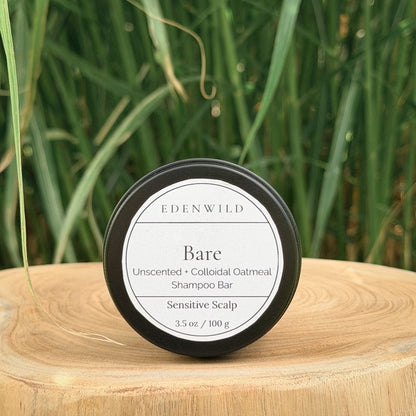 Edenwild Bare Shampoo Bar on wood stump pedestal with natural grass background — unscented colloidal oatmeal shampoo bar for sensitive scalp, fragrance-free and sulfate-free