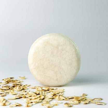 Edenwild Bare Shampoo Bar with colloidal oatmeal on grey background surrounded by rolled oats — unscented natural shampoo bar for sensitive scalp and eczema