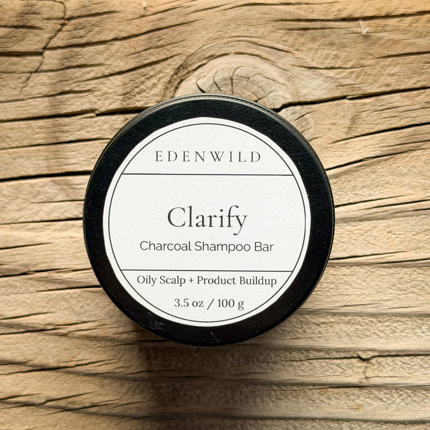 Edenwild Clarify Charcoal Shampoo Bar for oily scalp and product buildup, 3.5 oz, displayed on natural wood surface
