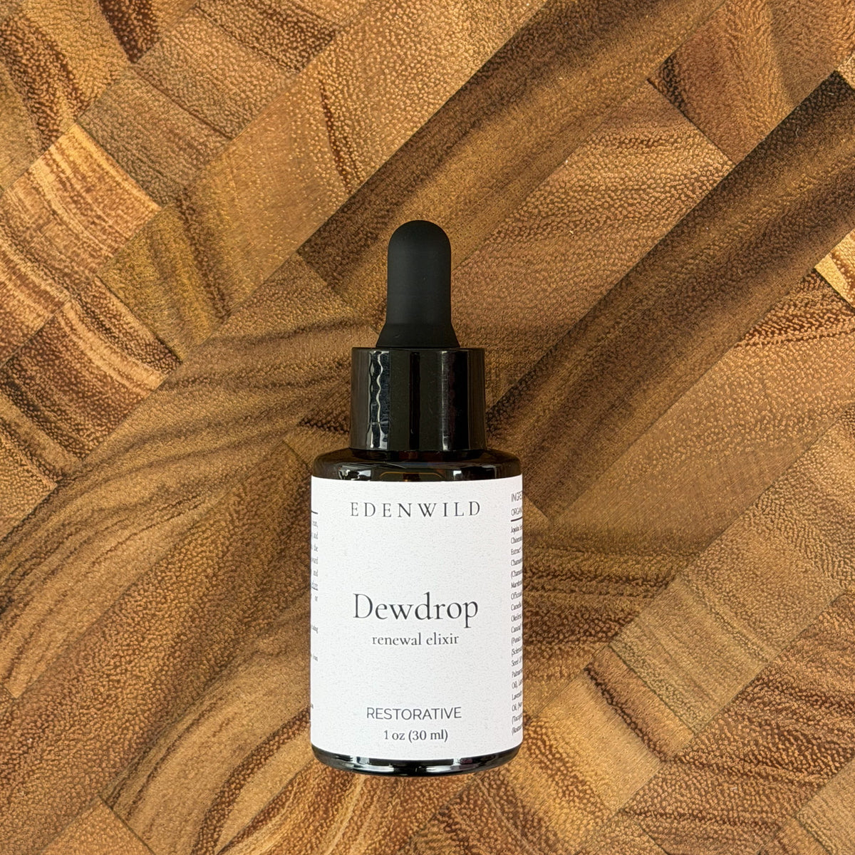 Edenwild Dewdrop Renewal Elixir face serum 1 oz on geometric wood background — restorative botanical serum for dry and sensitive skin