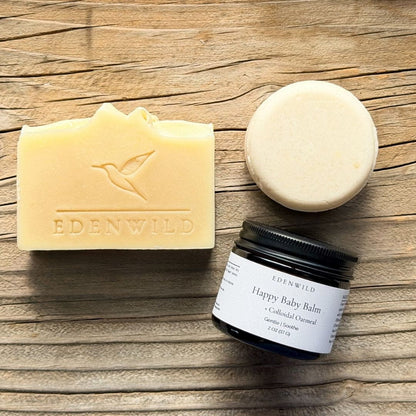 Edenwild Gentle Skin Trio — natural tallow soap bar, Bare Shampoo Bar, and Happy Baby Balm with Colloidal Oatmeal for sensitive skin, displayed on weathered wood