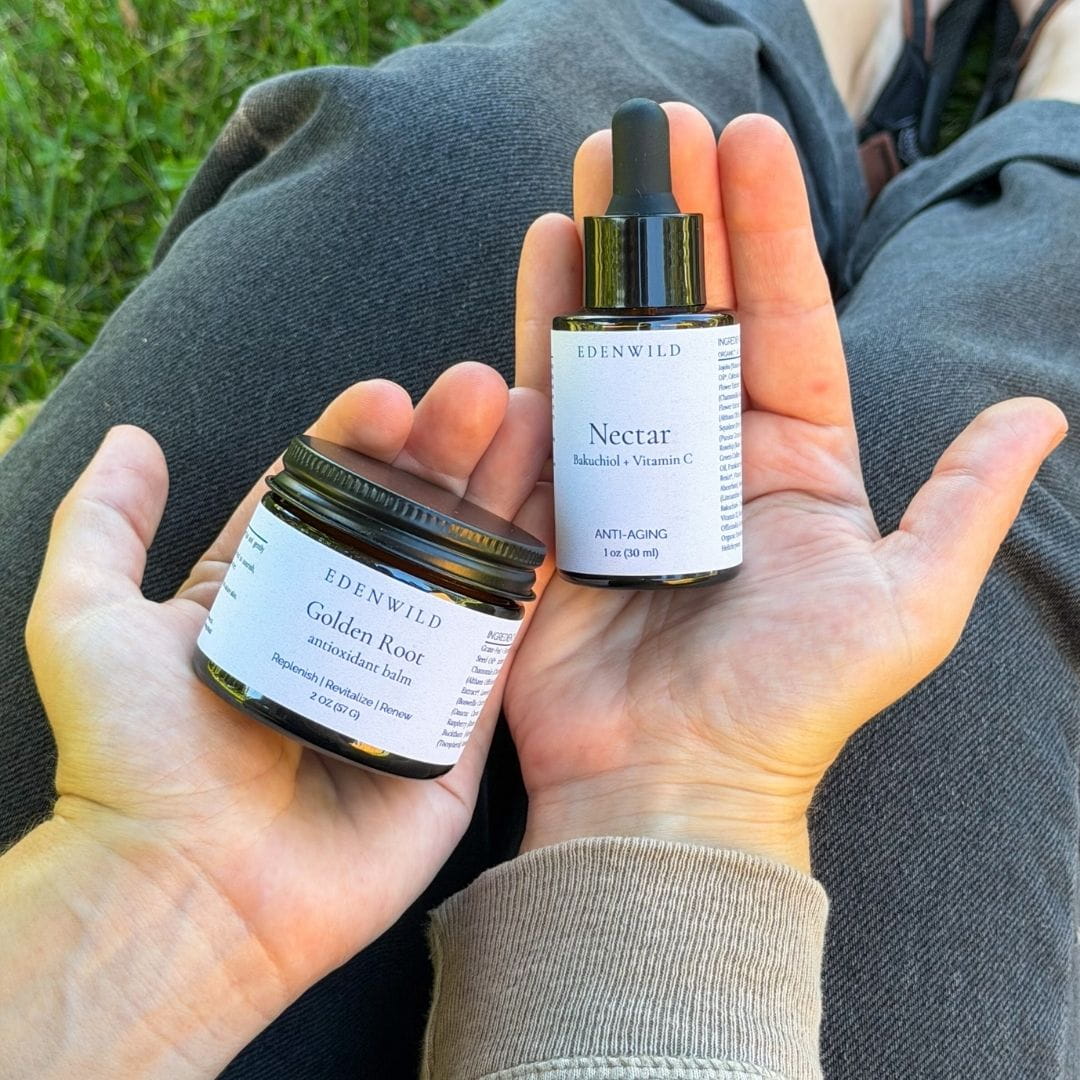 Hands holding Edenwild Golden Root Antioxidant Balm and Nectar Bakuchiol Serum outdoors — retinol-free natural anti-aging skincare set called Golden Hour