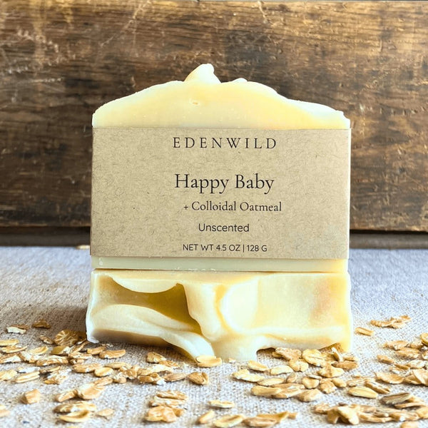 Edenwild Happy Baby Soap Bar with colloidal oatmeal displayed on scattered oats — unscented, organic soap bar for sensitive skin