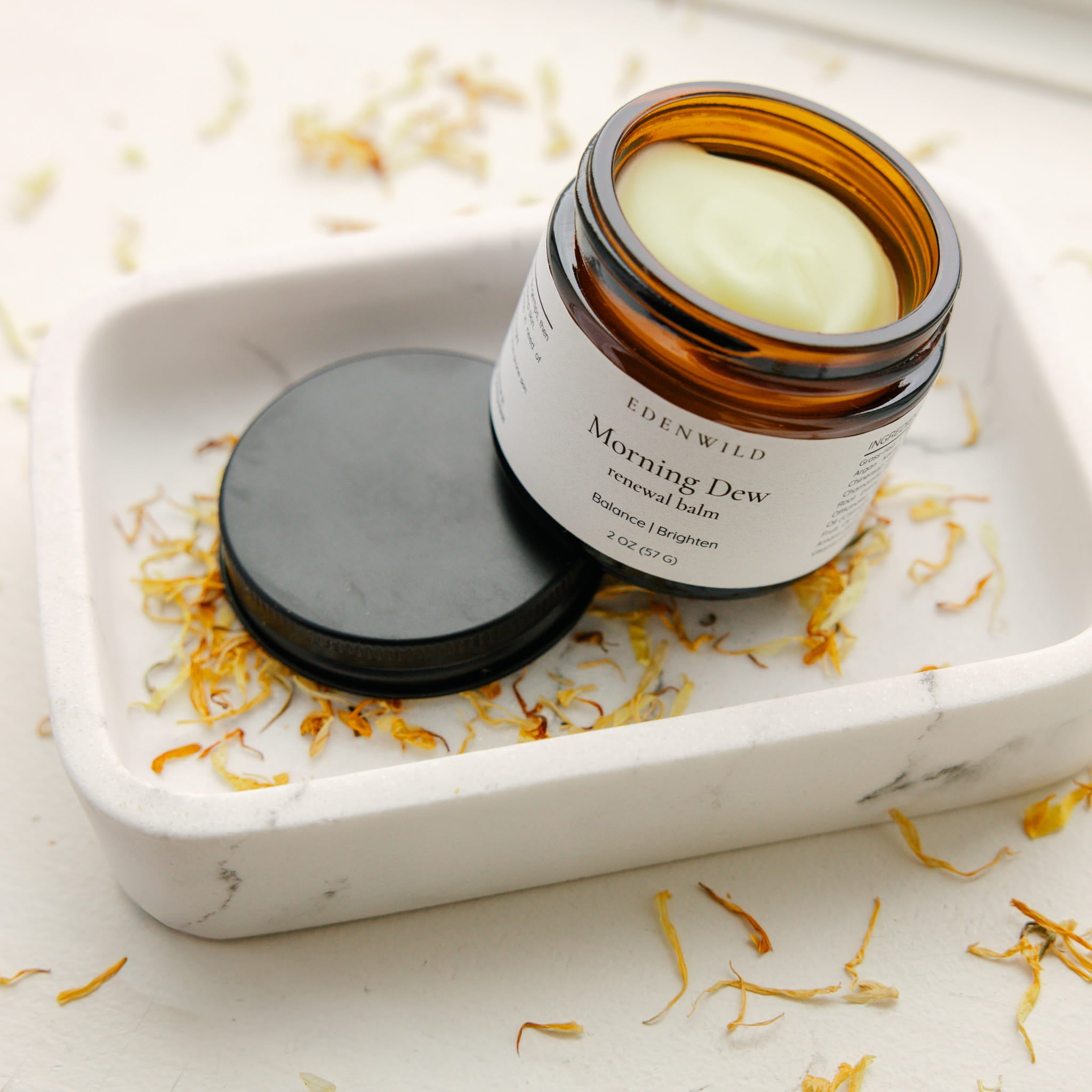 Edenwild Morning Dew tallow balm in an amber glass jar with dried calendula petals to help deeply hydrate and nourish dry and barrier-damaged skin