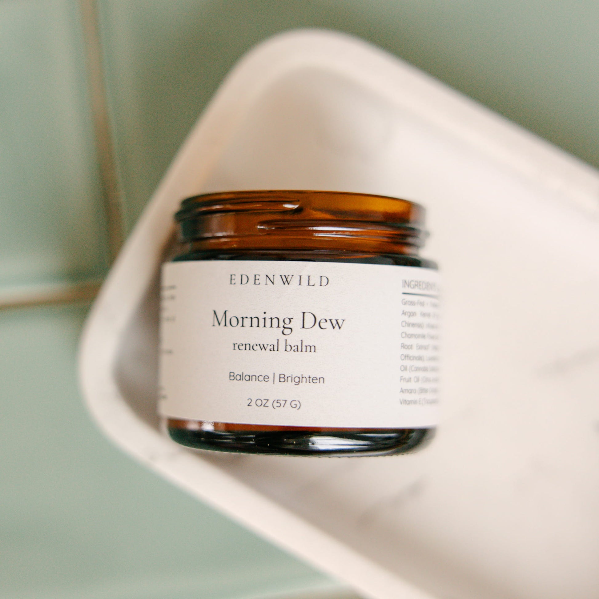 Edenwild Morning Dew renewal balm on sage green surface — botanical tallow balm for skin balance, radiance, and everyday nourishment
