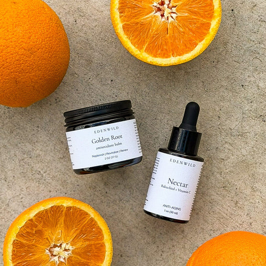 Edenwild Golden Root Antioxidant Balm and Nectar Bakuchiol Vitamin C Serum flat lay with fresh oranges — natural retinol-free anti-aging skincare duo Golden Hour