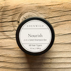 Edenwild Nourish 2-in-1 Solid Shampoo Bar for all hair types, 3.5 oz, in black tin on rustic wood background
