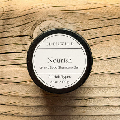 Edenwild Nourish 2-in-1 Solid Shampoo Bar for all hair types, 3.5 oz, in black tin on rustic wood background