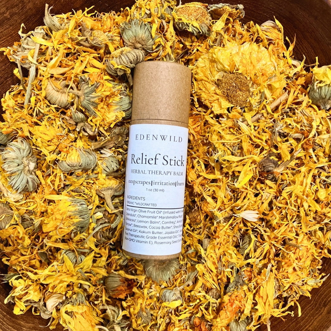 Edenwild Relief Stick herbal therapy balm nestled in dried calendula flowers — nature's Neosporin for cuts, scrapes, burns, irritation, and bug bites