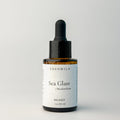 Edenwild Sea Glass serum facial serum in amber dropper bottle on grey background — botanical adaptogen serum for skin balance and barrier support
